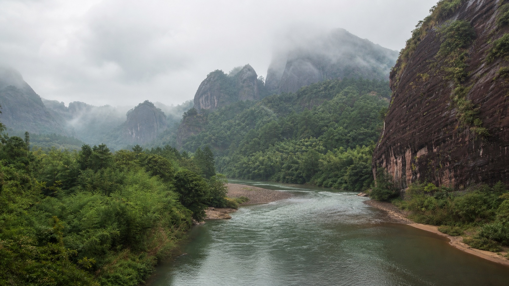 Jiuqu Stream winding through misty green peaks in Wuyishan
